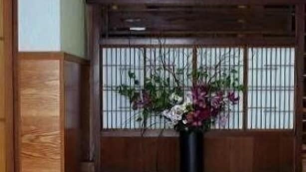 Una habitación japonesa tradicional con suelo de tatami, un banco de madera y una mesa baja.