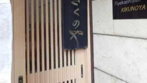 Entrada de un edificio con un letrero que dice "Ryokann (B&B) KIKUNOYAMA".