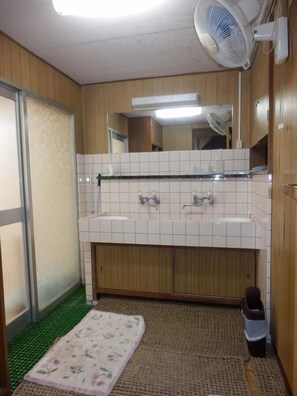 A bathroom with a white sink, mirror, and tiled walls.