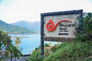 Une enseigne indiquant l’emplacement du complexe hôtelier Bhuvanir, avec en arrière-plan une vue sur un lac et des montagnes.
