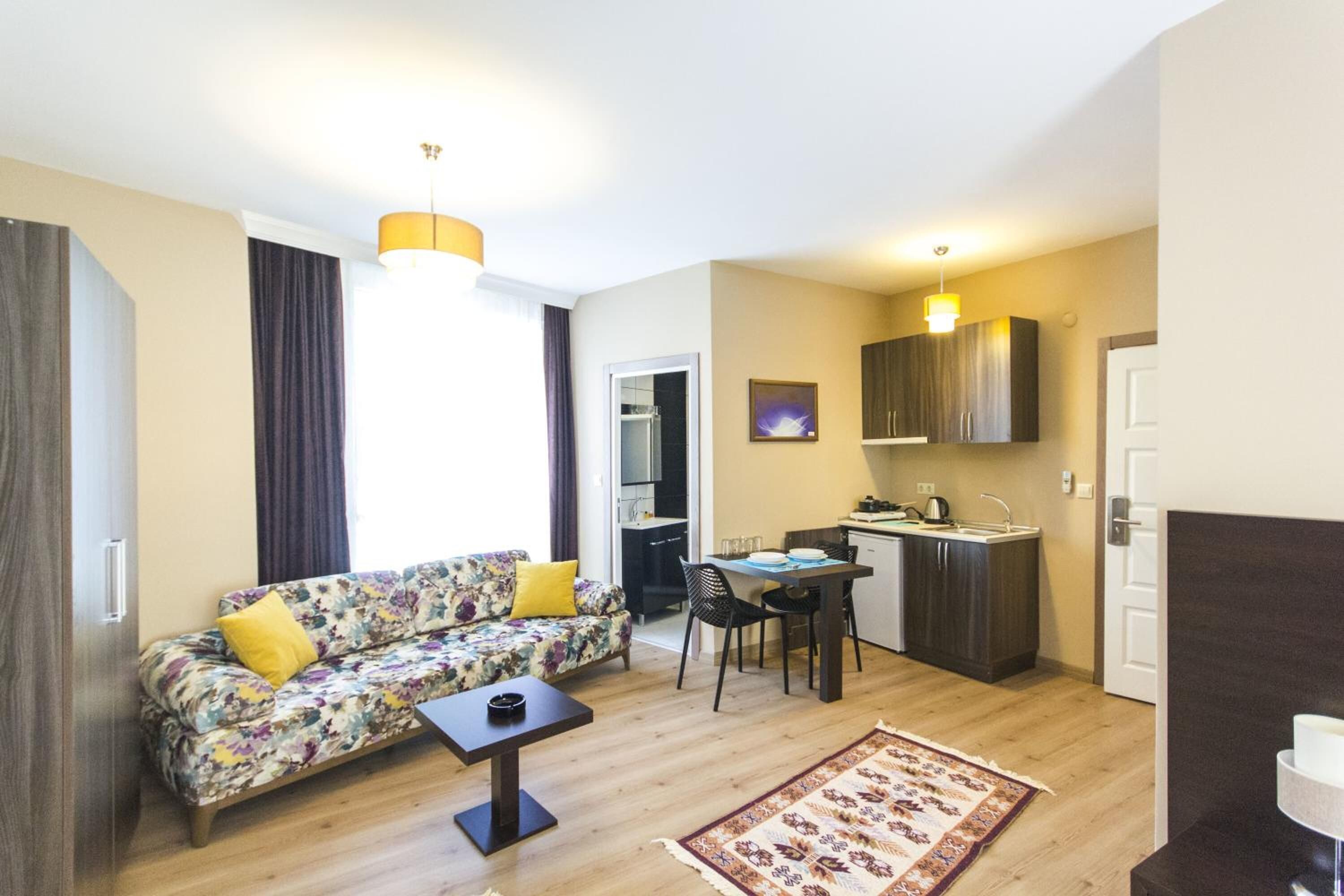 A compact living space with a sofa, a small table, a kitchen area, and a dining table.