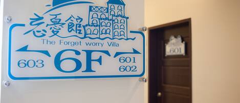 Un cartel que indica 'The Forget worry Villa' con los números de contacto 603, 601 y 602.