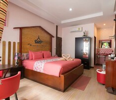 Habitación de hotel con cama, escritorio, silla, armario y espejo.
