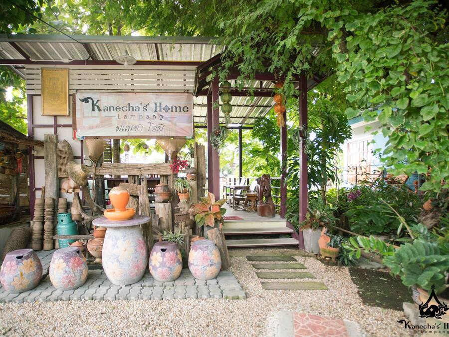 Um jardim com uma placa que diz 'Kanecha's Home Lampang'.