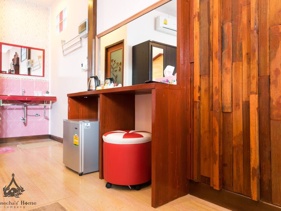 A compact kitchen with a sink, a refrigerator, and a red trash bin.