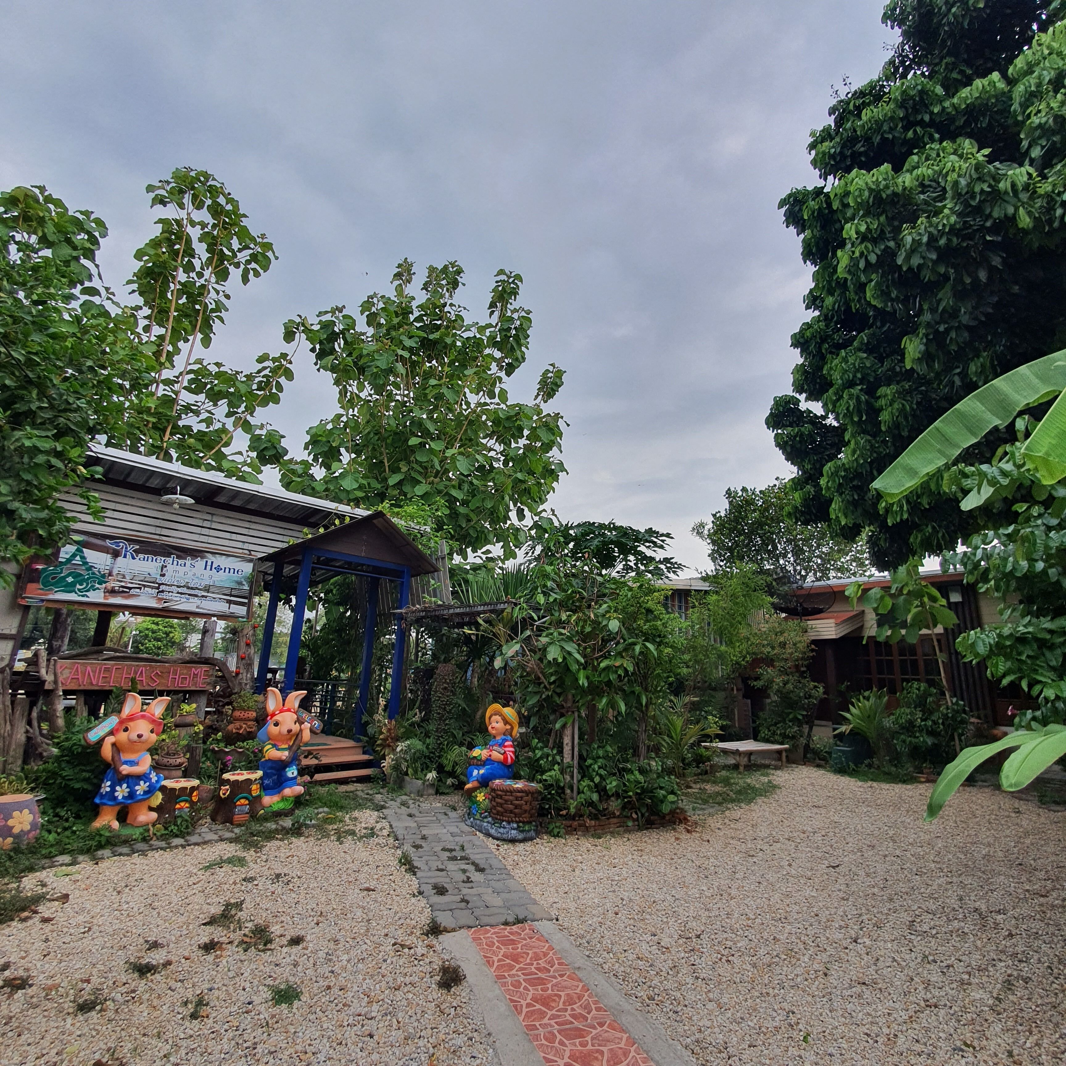 A garden area with a gazebo, a sign reading "Kanecha's Home," and two statues of children.