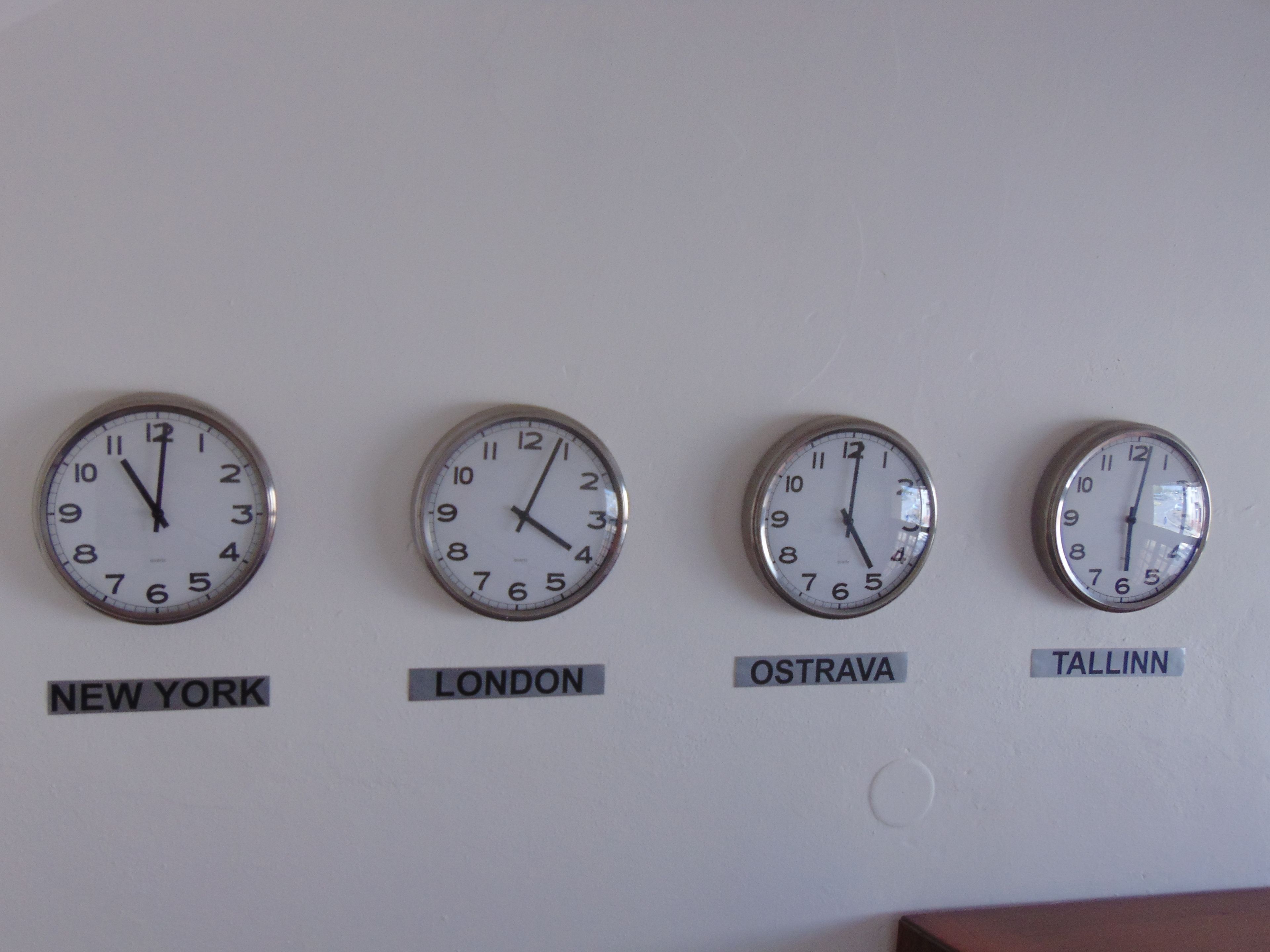 Four clocks labeled with city names: New York, London, Ostrava, and Tallinn.