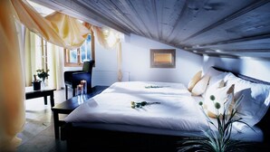A bedroom with a large bed, a desk, and a chair. - Griesalp Hotels (Reichenbach im Kandertal)