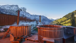 A wooden sauna with a chimney, a wooden bench, and a wooden deck. - Griesalp Hotels (Reichenbach im Kandertal)