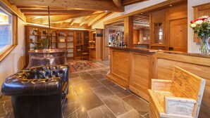 A wooden interior with a large copper still, leather seating, and wooden cabinets. - Griesalp Hotels (Reichenbach im Kandertal)
