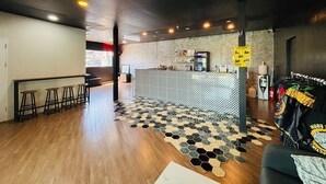 Un área de bar moderna con suelo de diseño hexagonal, taburetes y una barra con un motivo decorativo.