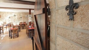 Un restaurant aux murs de pierre et au mobilier en bois.