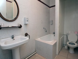 A bathroom with a sink, bathtub, and toilet. - Hotel le Chapeau Rouge (Chateau-Landon)