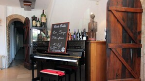Un piano sur lequel est posé un tableau noir servant de menu, où figurent des plats comme la « Cuvée Orelie » et le « Koni Burger ».