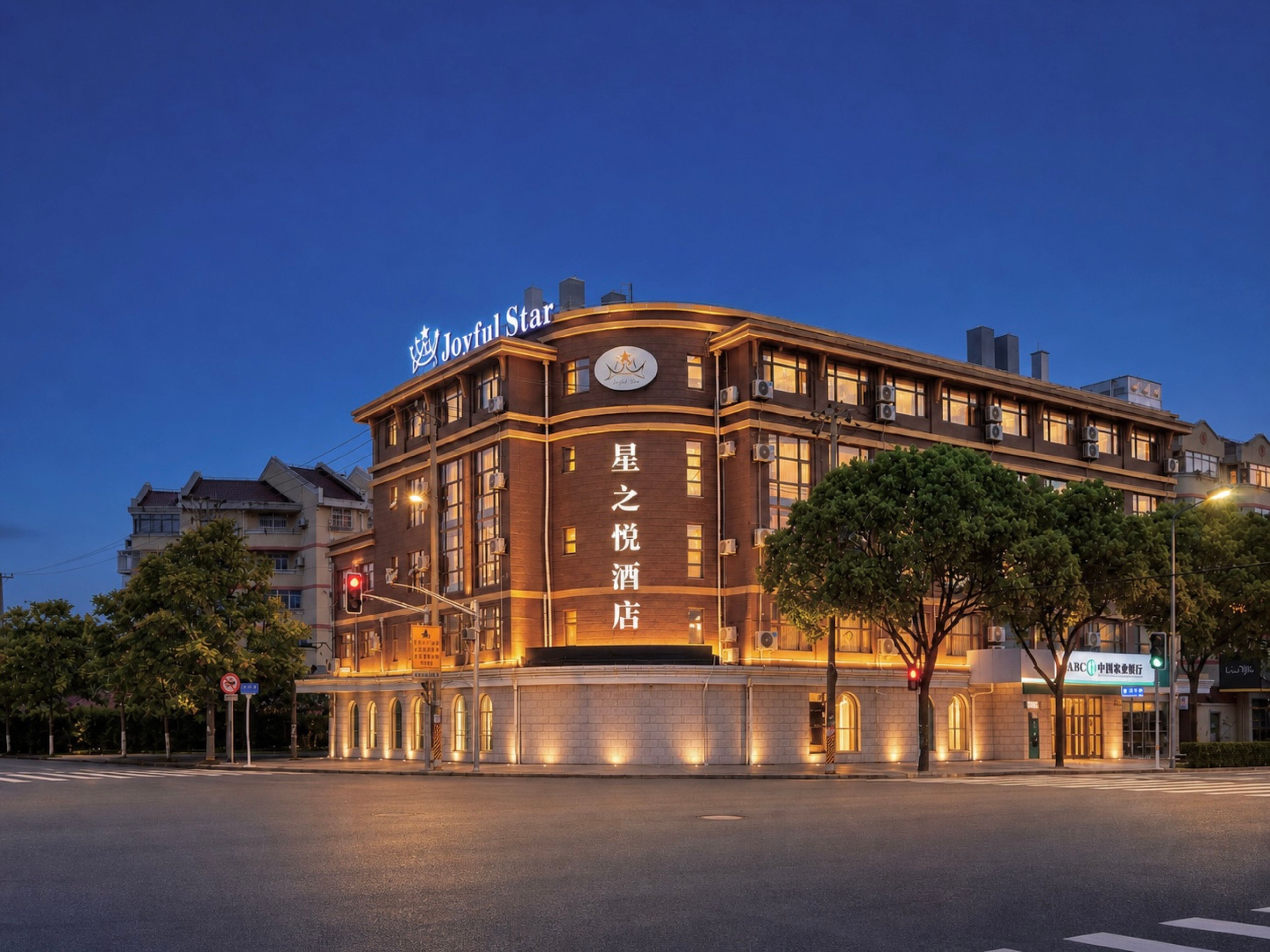 A hotel with a curved facade, illuminated signage, and a clear sky.