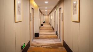 A long, narrow hallway with framed calligraphy on the walls, leading to a door at the end. - Shanghai Joyful Star Hotel (Shanghai)