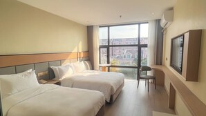 A hotel room with two beds, a desk, a chair, a TV, and a large window offering a city view. - Shanghai Joyful Star Hotel (Shanghai)