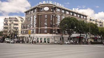 A multi-story hotel with a prominent clock on the facade, featuring a traditional architectural style with a symmetrical design and multiple windows.