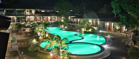 Un complexe hôtelier doté d’une grande piscine, de nombreuses chambres et d’un jardin aménagé.