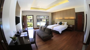 Una habitación de hotel moderna con cama, sofá, escritorio y televisor.