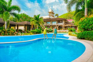 Una piscina al aire libre, sombrillas, tumbonas