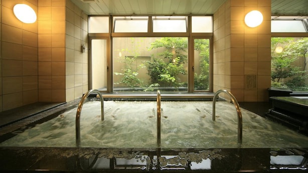 A hot spring bath with wooden walls and large windows. - Nagoya B's Hotel (Nagoya)