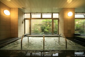 A hot spring bath with wooden walls and large windows. - Nagoya B's Hotel (Nagoya)
