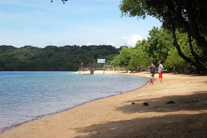 A beach with a wooden dock and a signboard. - White Sandy Beach Menjangan (Pejarakan)
