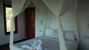 Uma cama com dossel, uma porta de madeira e uma janela com cortinas.