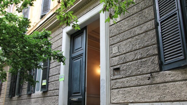 A building with a stone facade, a door with a window, and a small window with shutters. - Art Atelier Accomodation (Rome)