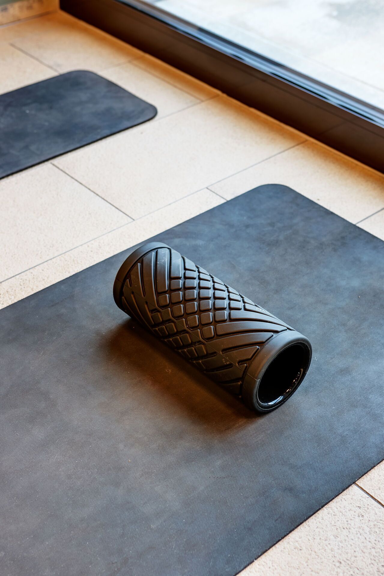 A yoga mat with a textured design on a floor.