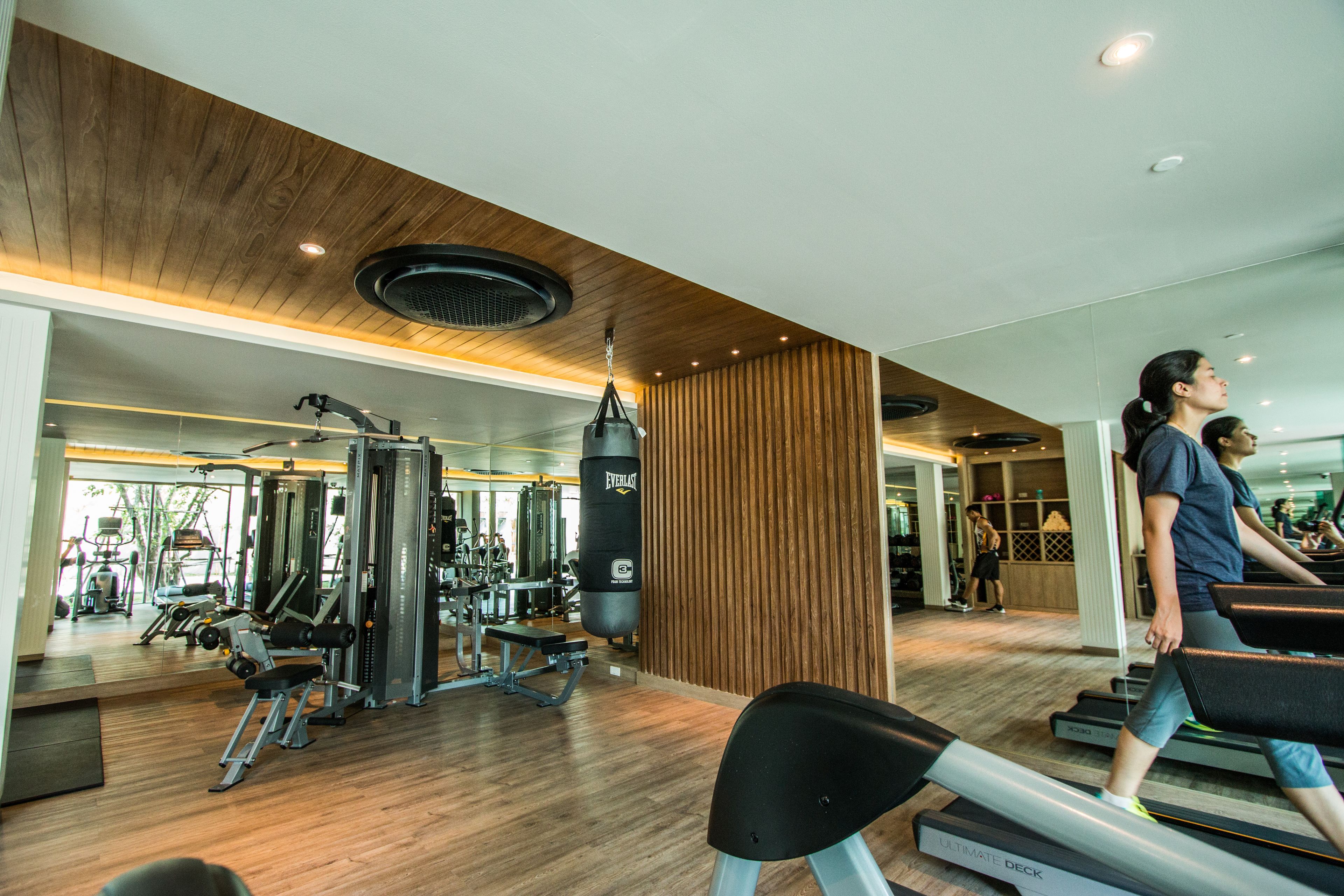 Un gimnasio con cintas de correr, máquinas de pesas y un saco de boxeo.
