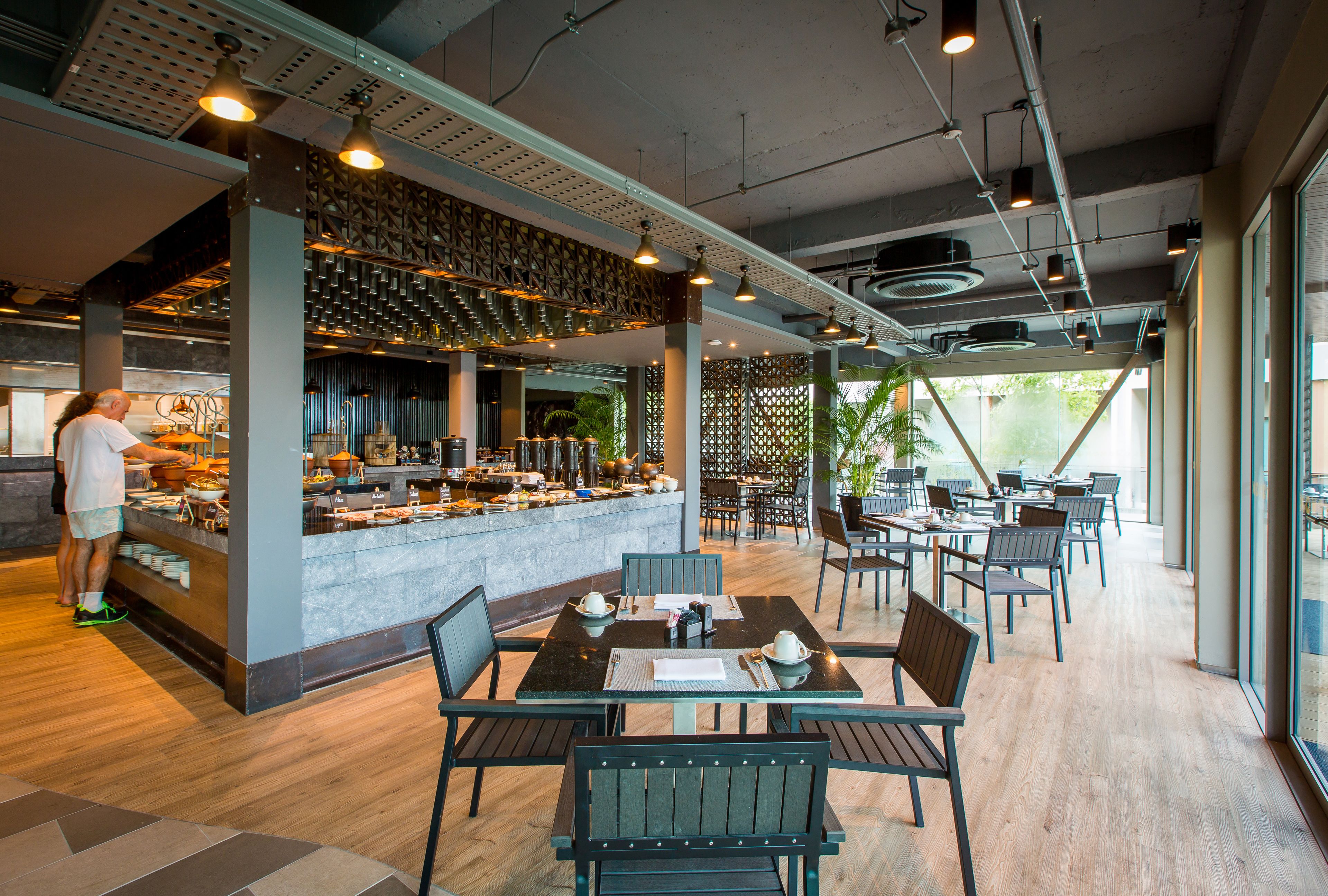 Un restaurante moderno con barra, mesas y sillas de madera.
