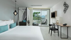 Een moderne hotelkamer met een groot bed, een bureau met stoel, een televisie en een balkon met uitzicht.