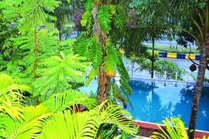 A lush indoor garden with various green plants and a clear blue pool. - Tropical Hill Kep (Kep)
