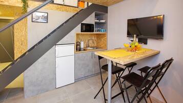 A modern kitchen with a built-in microwave, sink, and a dining area with a table and chairs.