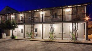 A two-story building with a balcony on the upper floor, a covered entrance, and outdoor seating. - Guverna New City Accommodation (Zadar)