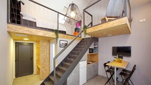 A modern kitchen with a built-in refrigerator, a dining table with chairs, and a TV mounted on the wall. - Guverna New City Accommodation (Zadar)