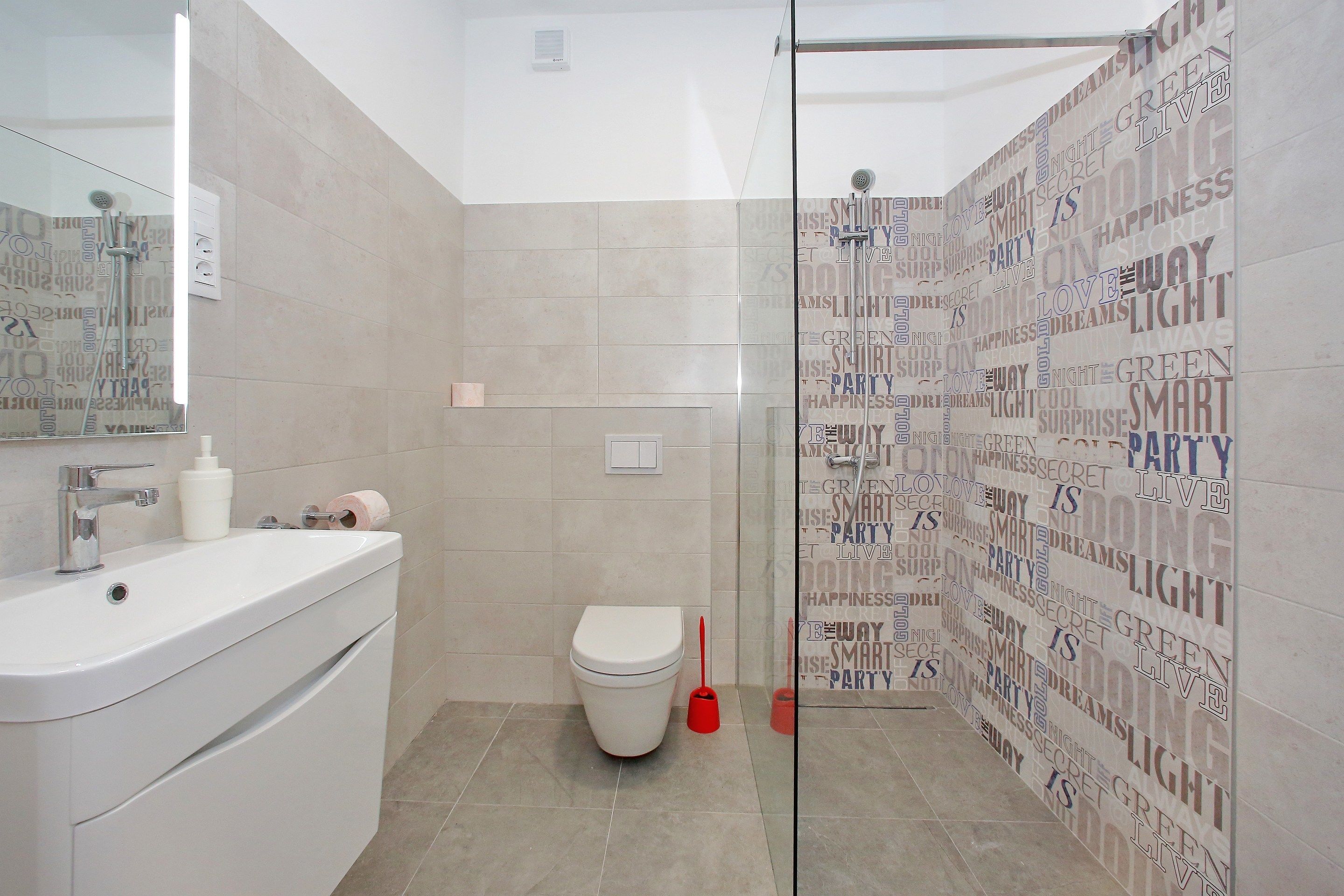 A bathroom with a white sink, toilet, and shower area.