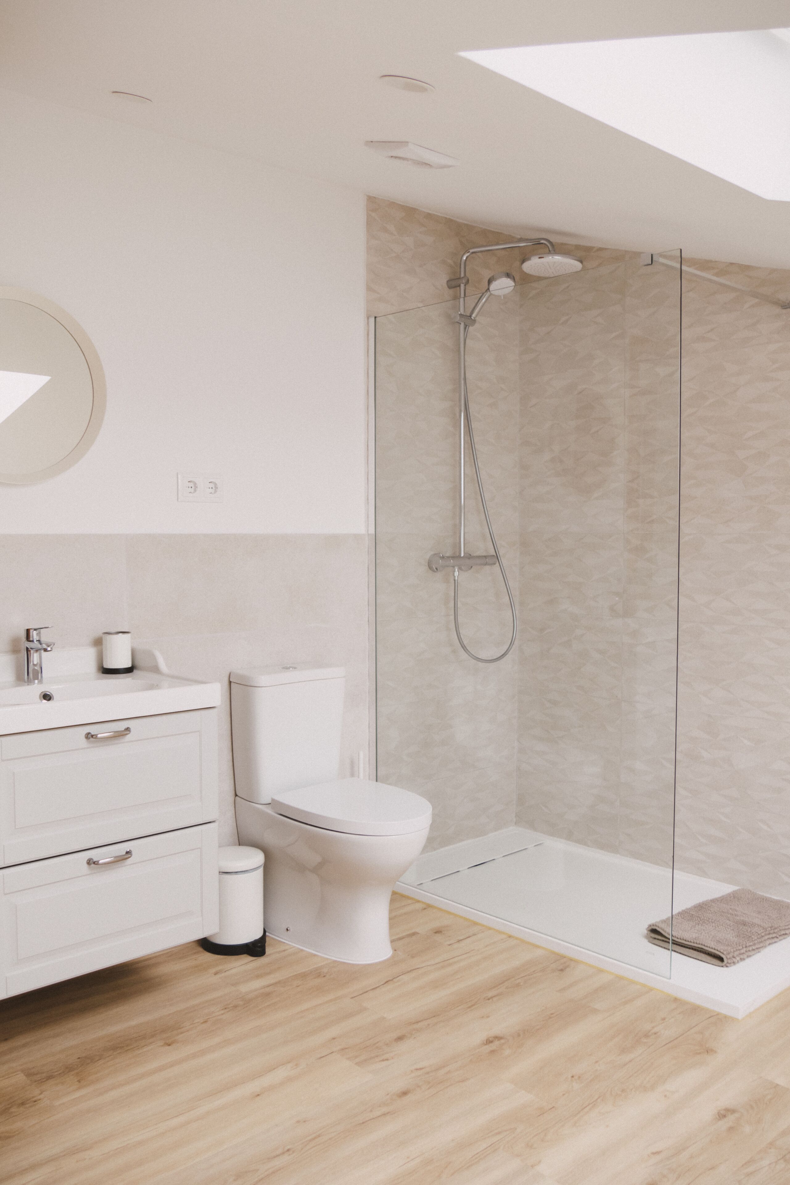 Un baño moderno con inodoro, lavabo y ducha.