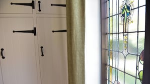Une pièce avec une porte blanche et une fenêtre ornée d’un vitrail décoratif.