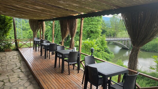 An outdoor deck with tables and chairs, overlooking a river and greenery. - Agva Green River Otel - Adults Only (Sile)