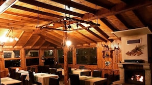A rustic dining area with wooden beams, tables set for dining, and a fireplace. - Agva Green River Otel - Adults Only (Sile)
