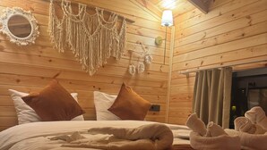 A wooden cabin room with a bed, pillows, a macrame wall hanging, and a lamp. - Agva Green River Otel - Adults Only (Sile)
