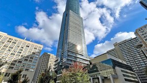 A tall, modern skyscraper with a glass facade, surrounded by other high-rise buildings. - Altitude Suites on Yonge (Toronto)