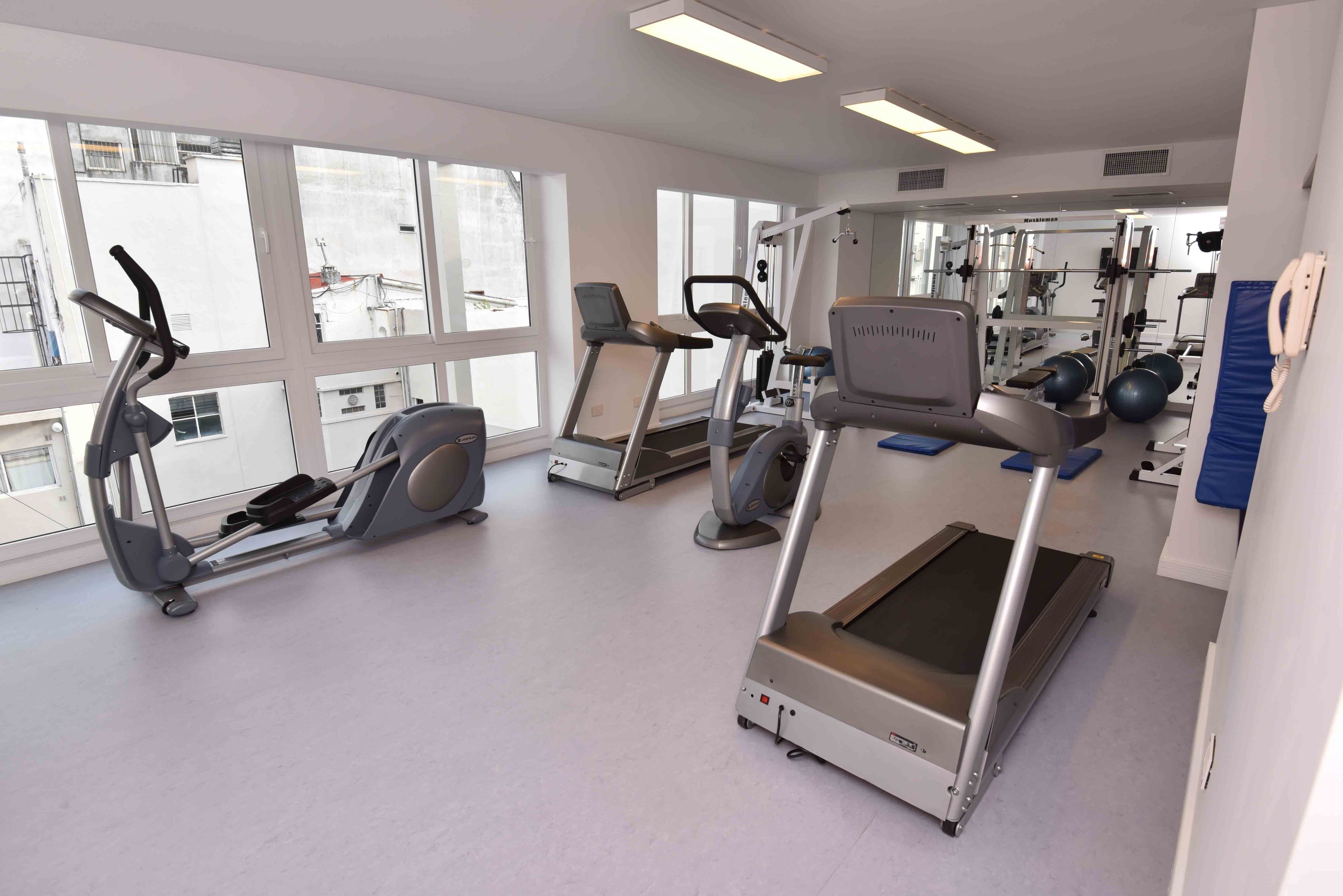 Une salle de sport équipée de tapis de course, de vélos elliptiques et de matériel de musculation.