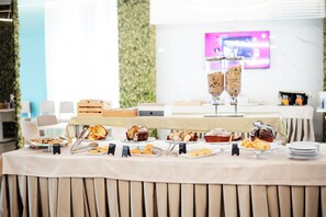 Una mesa de buffet con diversas opciones de panadería y pastelería.