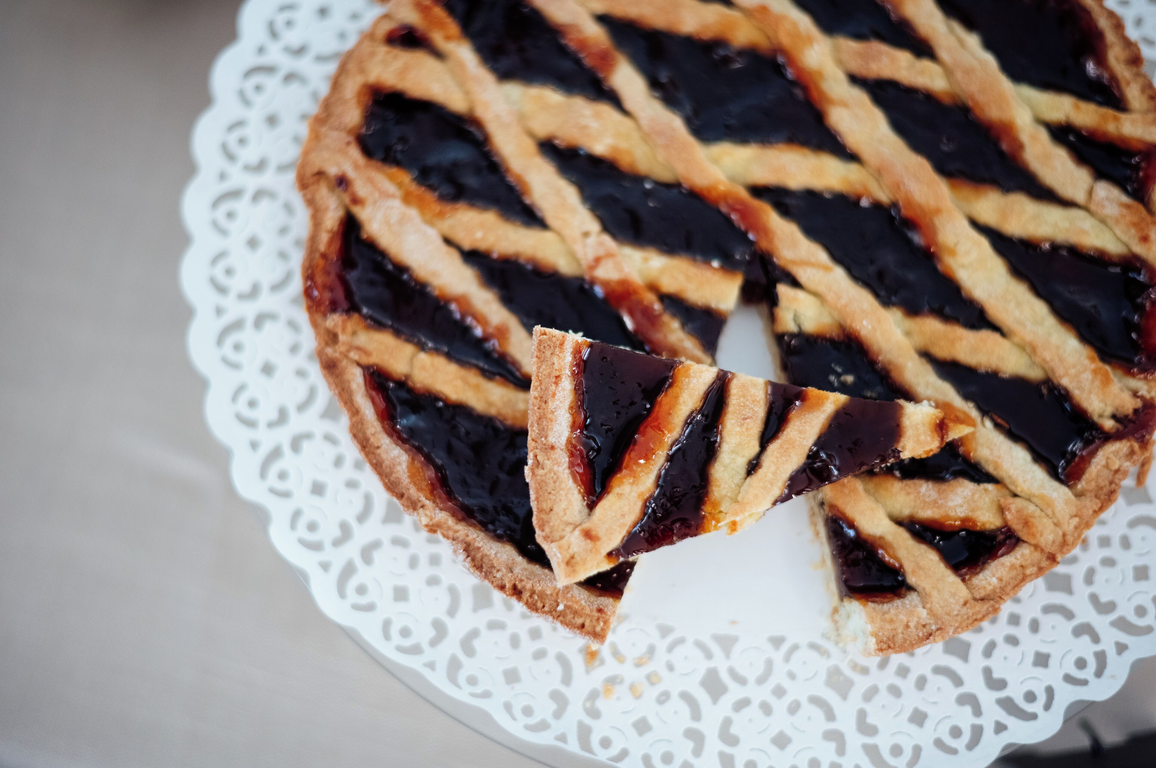 A pie with a lattice crust on a white doily.