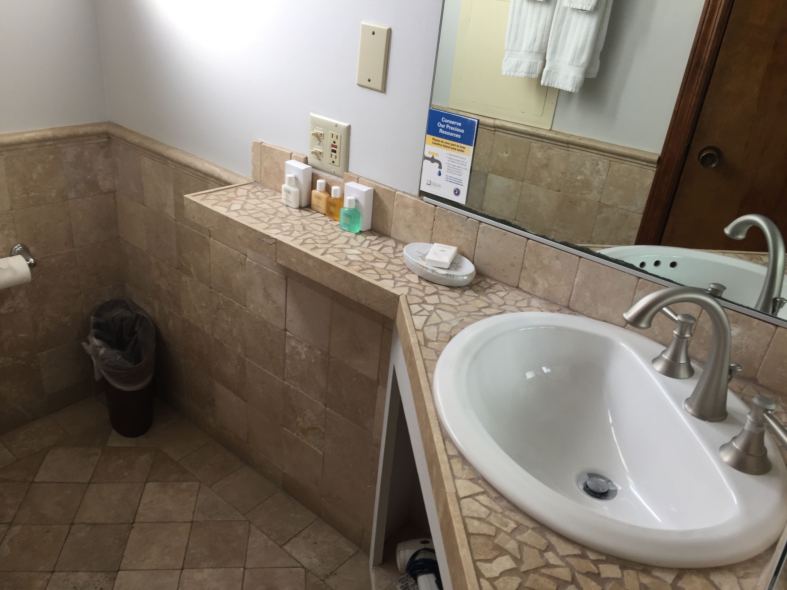Een badkamer met een wastafel, spiegel en toiletartikelen.