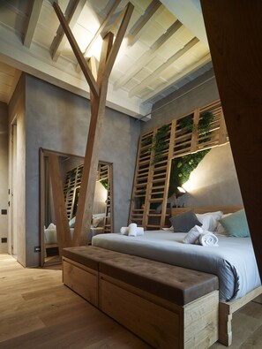 A modern bedroom with a large bed, wooden bench, and a unique ceiling design. - Benci House (Florence)